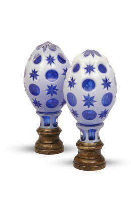 716.  Pareja de remates de escalera en forma de piña de cristal azul y opalina decorados con círculos y estrellas sobre base de metal.pp. del S. XX.