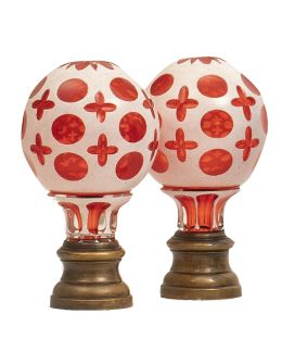 708.  Pareja de remates de escalera de cristal rojo y opalina con decoración de círculos y cruces sobre base de metal.Principios del S. XX.