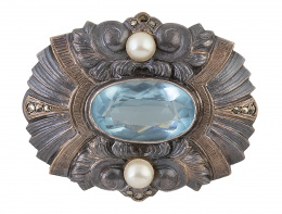 67.  Broche catalán Art-Decó con piedra azul oval central y dos perlas, en marco labrado con motivos geométricos y florales