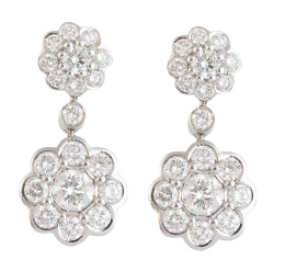 334.  Pendientes largos con dos rosetones de brillantes, el colgante de mayor tamaño, unidos por un chatón de brillante