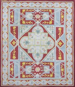 1145.  Alfombra en lana de nudo español, de estilo Carlos IV, en rojo, azul y amarillo.Firmada Miguel Stuyck.
