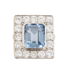 243.  Sortija de frente cuadrado con espinela sintética talla esmeralda, rodeada por marco cuadrangular de brillantes