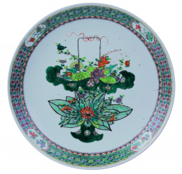 1148.  Plato compañía de Indias familia verde con jarrón vegetal central y alero reticulado decorado a base de pequeñas flores y cartelas en reserva.China, S. XIX