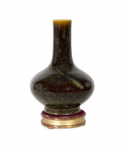 1065.  Botella globular en porcelana tipo flambe-glazed sobre peana de madera
