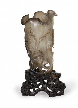 1401.  Copa de ágata tallada con motivos vegetales y una grulla que se extienden alrededor del recipiente sobre peana de madera tallada.China, Dinastía Qing, S. XIX - XX