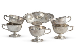 1265.  Lote de doce tazas de plata de ley 925 y una salvilla de pie alto.Joyería Camusso, Perú, S. XX.