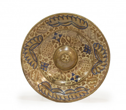 572.  Plato con umbo de cerámica esmaltada en reflejo dorado y azul de cobalto decorado con piñas, hojas y flores.Manises, S. XVI.