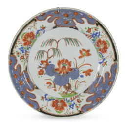 667.  Plato de porcelana esmaltada en rojo, azul y dorado y negro.China, XVIII.