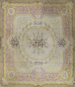 1218.  Alfombra en lana de nudo  español, con campo beige y enefa en rosa con flores. Firmada y Fechada (ilegible).Madrid.