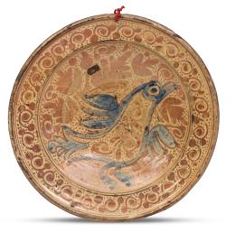 1094.  Plato de cerámica esmaltada de reflejo metálico, decorado con pájaro en azul cobalto, con hojas y puntos.Manises, S. XVIII.