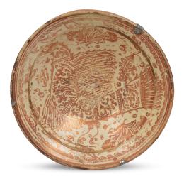 1097.  Plato acuencado de cerámica esmaltada dereflejo metálico con "parladot" y matas de clavelinas.Manises, S. XVIII.