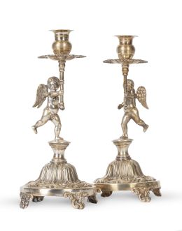 1241.  Pareja de candeleros de plata con puttis.Uno con etiqueta de la Joyería Agruña, S. XX.
