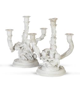 1102.  Pareja de candelabros de tres brazos de luz de biscuit con puttis. Con marcas incisas de "Ls" entrelazadas.París, h. 1900.