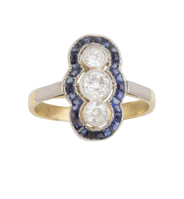 128.  Sortija lanzadera Art-Decó con tres chatones de brillantes de talla antigua rodeados por marco lobulado de zafiros