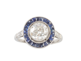 305.  Sortija solitario ojo de perdiz con un brillante central de 1,36 ct aprox orlado de zafiros calibrados en talla francesa