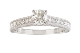 248.  Sortija con solitario de brillante, con brazos de la montura adornados con brillantes en frente y laterales