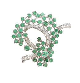 315.  Broche de esmeraldas y brillantes en diseño floral, que combina cinta anudada de pavé de brillantes con esmeraldas a modo de flores engastadas a diferentes alturas