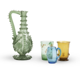 643.  Lote de cuatro piezas de cristal. Formado por:Jarro en cristal verde*, probablemente Almería, S. XVIII-XIX; Jarro en vidrio verde con decoración aplicada, Cataluña (?), S. XVIII; Jarra de cerveza en vidrio azul, Andalucía, S. XVIII-XIX; Vaso en vidrio color ámbar, Cataluña, S. XVIII. 
