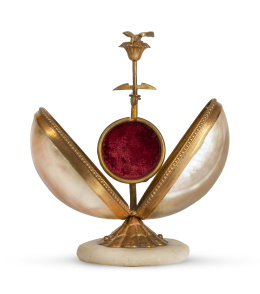 1261.  Guardarretratos de nácar montado en metal dorado, rematado por ave, con base de piedra.h. 1900.