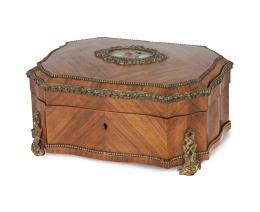 1245.  Caja Napoleón III de madera de palo de rosa con bronce dorado y placa de porcelana esmaltada a la manera de Sévres con dos puttis.Trabajo francés, último cuarto del S. XIX.