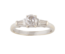 213.  Sortija solitario con brillante central flanqueado por dos diamantes talla trapecio