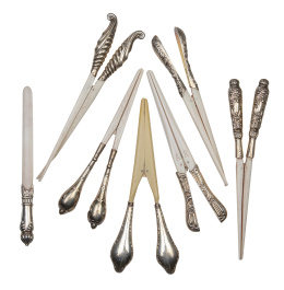 1229.  Lote de seis pinzas para guantes y un abrecartas en hueso y plata. Con marcas.