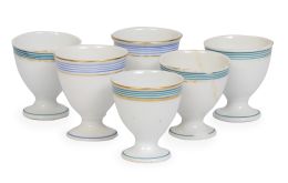 702.  Lote de seis hueveras de porcelana esmaltada y dorada, cuatro de ellas con rayas turquesa y dos azules.Principios del S. XX.