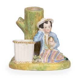 700.  Florero de biscuit pintado y dorada con niño apoyado en cesto.Inglaterra, h. 1900.