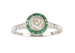 120.  Sortija ojo de perdiz con centro de brillante de talla antigua, orlado de esmeraldas calibradas, con diamantes adornando los brazos de la montura