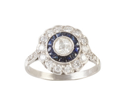 73.  Sortija ojo de perdiz de zafiros y brillantes estilo Art-Decó, con brillante central orlado de zafiros calibrados, y orla exterior lobulada de brillantes