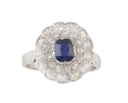93.  Sortija rosetón de brillantes con zafiro central de talla oval, con doble orla de brillantes, la exterior en marco lobulado