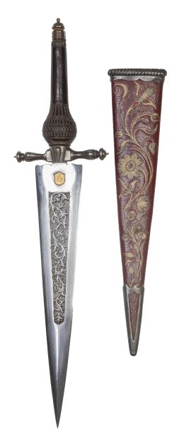 1092.  Manuel Fernández*.Cuchillo de caza Carlos IV, con empuñadura de madera tallada, acero calado con hojas y vaina de piel bordada con flores. Con sello "M To F".Toledo, principios del S. XIX.