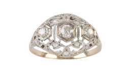 82.  Sortija Art-Decó de diamantes en frente bombée, calado y coronado por tres brillantes de talla antigua