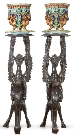 1143.  Pareja de maceteros en loza esmaltada, en marrón verde y azul. Sobre peanas de madera tallada en forma de grifos.Sarraguemines, Francia, h. 1890.