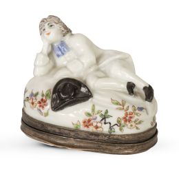 1310.  Bombonera de porcelana esmaltada, montada en plata, con un personaje recostado y flores. Marca en rojo en el interior.Samson, siguiendo a Chantilly, Francia, mediados del S. XIX.