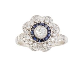 101.  Sortija flor estilo Art-Decó, con centro de ojo de perdiz de brillante y zafiros calibrados y orla exterior lobulada de brillantes