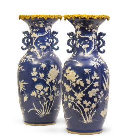 581.  Pareja de jarrones de porcelana esmaltada en azul y blanco, decoración en relieve de flores y hojas de bambú, montados en bronce dorado.China, dinastía Qing.