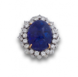 761.  Sortija con gran cabuchón de tanzanita entre dos  orlas de brillantes engastados en diferentes alturas.