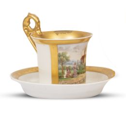 670.  Taza con su plato de porcelana esmaltada y dorada con paisaje. Con marca en la base.París, S. XIX.