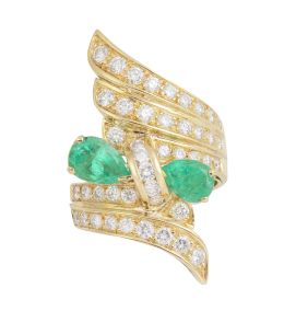 263.   Sortija ancha con diseño de alas de brillantes y centro de lazo de brillantes y dos esmeralda talla pera