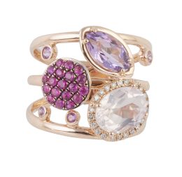 282.  Sortija ancha con tres motivos, rubíes, amatista y zafiro blancos en aro formado por tres anillos