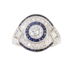 311.  Sortija estilo Art-Decó de brillantes y zafiros, con centro de ojo de perdiz con brillante de 0,65 ct aprox, orlado de zafiros y con marco de brillantes perfilado por zafiros calibrados