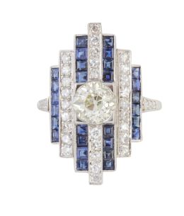 358.  Sortija lanzadera  de brillantes y zafiros estilo Art-Decó, con bandas verticales alternas de brillantes y zafiros y brillante en chatón central