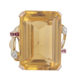 143.  Sortija chevalière años 40 con gran cuarzo citrino, central flanqueado por dos lazos decorados con brillantes y rubís sintéticos