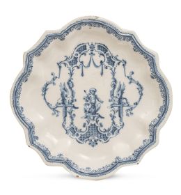 1045.  Plato de cerámica esmaltada en azul y blanco de la serie de la puntilla Berain.Alcora, primera época, (1727-1749).