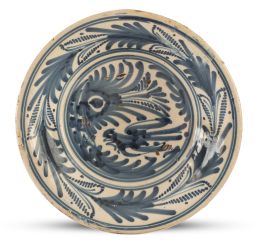 1099.  Plato de cerámica esmaltada en azul y blanco de la serie de la golondrina y hojas de palma.Talavera, S. XVIII.