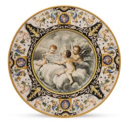 1045.  Jafet Torelli. Firmado en el reverso. "J.Torelli. Firenze".Plato historicista de cerámica esmaltada con tres puttis, siguiendo modelos del S. XVI.Florencia, último cuarto del S. XIX.