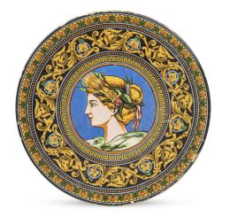 1047.  Plato de cerámica esmaltada con una alegoria de perfil y cenefa de hojas carnosas.Alba Andújar, h. 1900.
