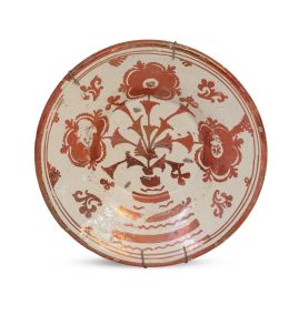 576.  Plato acuencado de cerámica esmaltada de reflejo metálico con flores.Manises, S. XVIII.