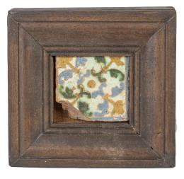 1109.  Olambrilla de cerámica de arista esmaltada en verde, azul y melado, con decoración vegetal, con marco de madera.Toledo, S. XVI.